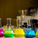 Colorful solution in conical flask lined on a bench in a chemistry lab with blur background organic chemistry experiment photography